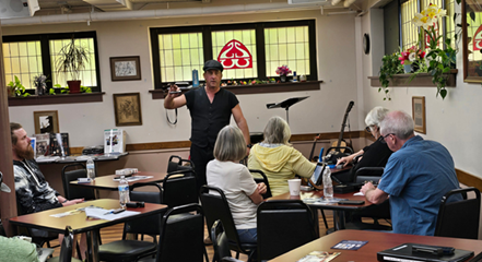 Lil' Rev showing workshop participants how to hold the harmonica